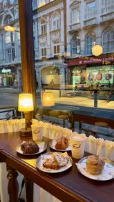Two foodies enjoying flaky pastries at Fred Bakery, known for delicious, generous fillings and a cozy atmosphere.