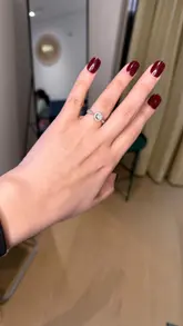 Person showcasing colorful press-on nails while enjoying a moment of self-admiration.