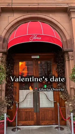 Couple enjoying a romantic meal at Gloria Osteria in Dublin for Valentine's Day, surrounded by flowers and warm ambiance.