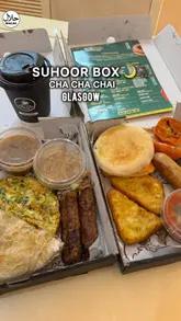 A short video showcasing the 'Suhoor box' from Cha Cha Chai, featuring both Desi and English breakfast options. The video highlights the contents of the boxes, including paratha, kebabs, and egg muffins, alongside shots of the cafe interior and drink dispensers.