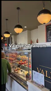 Alt text: "Enjoying Sunday treats at Valerie's Tearoom, including chicken wrap, corned beef slice, and chocolate cake.