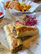 A casual, top-down shot of a kofte wrap and a chicken fajita, served on branded paper. The photo is a standard, user-generated style, capturing a meal at a casual dining venue.