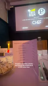 A first-person vlog documenting a 'Taste Film' event where the viewer watches the movie 'Chef' while eating a themed, plant-based menu. The video features various dishes served during the film, including a Cuban sandwich, pasta, and lava cake, providing a glimpse into the immersive dining experience.