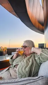 Given the caption "Dreaming of summer and long leisurely weekend lunches…🌅🍹" and the tags "@whotels @greenwoods.edinburgh @stockbridgeeatinghouse", the image likely shows:

**Alt Text:** People enjoying summer cocktails and a leisurely lunch on an outdoor patio at Stockbridge Eating House in Edinburgh.