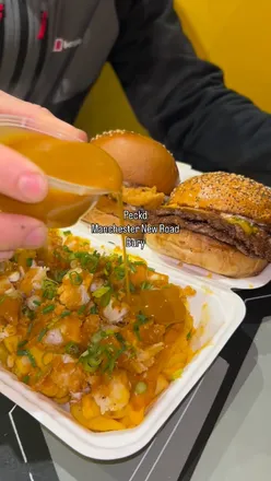 Indulge in a flavor-packed burger dunked in house dip at Peck in Bury, featuring buffalo, cheesy, curry, and spicy options.