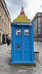 A vlog-style review of Cheese Box Glasgow, a unique street food venue operating out of a converted police box. The video showcases the preparation of raclette sandwiches, cheesy baguettes, and Basque cheesecake, highlighting the cozy heated seating area and the friendly service.