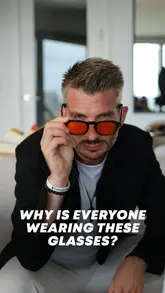 A person wears orange blue light blocking glasses at night to help filter screens and lights, promoting relaxation and better sleep.