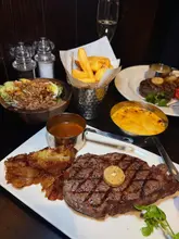 Here are a few options for your SEO alt text (under 125 characters):

*   **Option 1 (Descriptive):** Delicious steak, triple-cooked chips, and chocolate dessert at the newly refurbished Miller & Carter Marlbrook.
*   **Option 2 (Action-oriented):** Friends enjoying a sophisticated steak dinner and sharing a chocolate dessert at Miller & Carter Marlbrook.
*   **Option 3 (SEO-focused):** Steak, mac and cheese, and chocolate pudding served at the newly renovated Miller & Carter Marlbrook restaurant.

**Recommendation:** Option 1 is best for accessibility and SEO as it clearly states the food and the specific restaurant location.