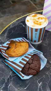 Here are a few options, choose the one that best matches the visual details of the image (since I can't see it):

**Option 1 (Focus on cozy morning):**
"Delicious freshly baked cookies from Bear Street Bakery, beautifully arranged for a dreamy morning with a warm beverage." (115 characters)

**Option 2 (More direct product focus):**
"A delightful array of freshly baked cookies from Bear Street Bakery, perfect for a dreamy morning coffee." (107 characters)

**Option 3 (Emphasizing the bakery):**
"Cozy morning scene featuring delicious cookies from Bear Street Bakery, artfully presented with a cup of coffee." (109 characters)

I recommend **Option 1** as it strongly incorporates the "dreamy morning" from the caption while being descriptive and including the brand.