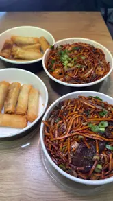 Crispy golden spring rolls and a generous plate of beef chow mein from The Wok Station Chinese takeaway in Manchester.