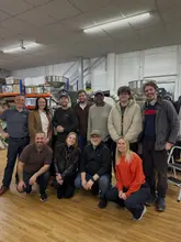Students actively learning coffee roasting techniques using professional equipment at a coffee school.
