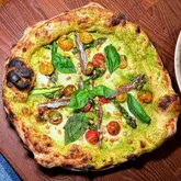 Asparagus pizza with mozzarella, anchovies, pine nuts, and cherry tomatoes at Marco's pizzeria in London.