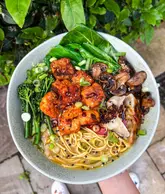 Two beautiful ramen bowls, one appearing as a delicious vegan ramen, with rich broth, noodles, and fresh, colourful toppings.