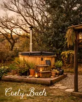 Romantic Mid Wales cabin getaway: a couple enjoying a starlit outdoor bath and wood-fired hot tub at Coety Bach.