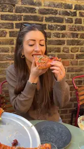 A short video showcasing a pizza restaurant's terrace, menu, and food items like pizza and eggplant parmigiana.