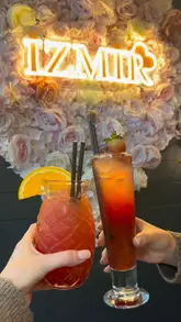 A promotional video for Izmir restaurant in Milton Keynes, featuring a montage of cocktail preparation, various Mediterranean dishes being served, and interior shots of the venue.