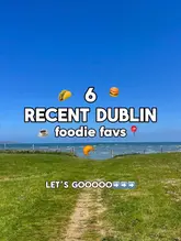 A scenic landscape photo of a grassy field leading to the sea, used as a cover image for a listicle video about Dublin food spots.