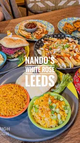 Here are a few options for your SEO alt text, depending on the specific focus of the image:

**Option 1 (Focus on the restaurant interior):**
Stylish, modern interior of the newly refurbished Nando’s restaurant at White Rose Shopping Centre in Leeds.

**Option 2 (Focus on the food):**
A delicious spread of Nando’s chicken wings and DIY pitta meals at the newly refurbished Nando’s in White Rose, Leeds.

**Option 3 (Focus on the brand/vibe):**
The new, modern dining area at Nando’s White Rose, Leeds, featuring fancy furniture and signature PERi-PERi chicken.

**SEO Tip:** If the image shows a specific dish, mention the dish name (e.g., "Nando's PERi-PERi wings"). If it shows the decor, emphasize the "refurbished" aspect as that is a strong local search hook.