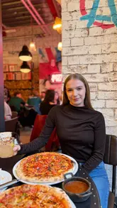 A short promotional video featuring a creator visiting Pizza Punks, showcasing the interior, cocktails, and various pizza options.
