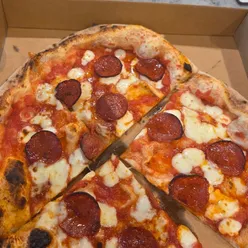 Freshly baked pepperoni pizza slice with honey drizzle at Marco's Pizza Mia stall in Kidbrooke, London.