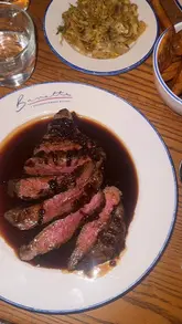 Here are a few options for your SEO alt text, keeping under the 125-character limit:

**Option 1 (Focus on the food):**
"Gourmet dishes including steak, artichoke tart, and chocolate tart served at Bavette bistro in Horsforth."

**Option 2 (Descriptive & location-based):**
"Close-up of delicious French-inspired bistro dishes and cocktails at Bavette restaurant in Horsforth."

**Option 3 (Social/Vibe focused):**
"Table spread of gourmet French cuisine and cocktails inside the stylish Bavette bistro in Horsforth."

**SEO Tip:** If the photo shows a specific dish (like the potato fondant), make sure to mention that in the text as it is a high-intent search term for this specific restaurant!