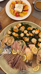 The creator documents a day on the Isle of Wight, visiting a local bakery for coffee and a croissant, a fishmonger for fresh seafood, and a greengrocer for produce. The video concludes with the creator preparing a fish platter dinner at home with the help of her toddler.