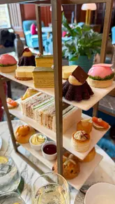 Elegant afternoon tea at Mar Hall Resort in Scotland. Table with delicate sandwiches, scones, pastries, and champagne.