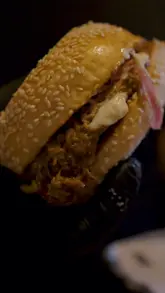 A food review video where the creator visits Black Bear Burger in Westfield Shepherd's Bush, showcasing various starters and a brisket burger, providing an honest critique of the food quality.