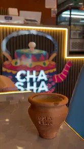 Here are a few options for your SEO alt text, keeping it under 125 characters:

**Option 1 (Descriptive & SEO-focused):**
A colorful, modern interior of Cha Sha restaurant on Cowbridge Road East in Cardiff serving authentic desi food.

**Option 2 (Focus on the food):**
Table spread of desi breakfast, biryani, and matka chai at the newly opened Cha Sha restaurant in Cardiff.

**Option 3 (Short & punchy):**
Vibrant interior and delicious Halal desi breakfast and lunch dishes at Cha Sha Cardiff on Cowbridge Road East.

**Best practice tip:** If the image is a specific photo of the food, use Option 2. If it is a shot of the restaurant's decor, use Option 1 or 3.
