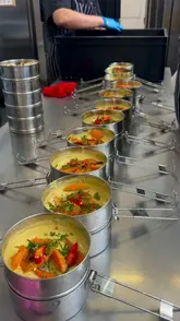 The video provides a behind-the-scenes look at a collaboration between a tiffin delivery service and a chef, showcasing the preparation of Singaporean-inspired dishes and the delivery process.