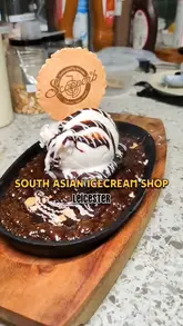 Here are a few options for your SEO alt text, keeping it under 125 characters:

**Option 1 (Descriptive):**
Scoops of guava and chickoo ice cream topped with chilli seasoning at Scooperb in Leicester city centre.

**Option 2 (Focus on the experience):**
Two scoops of South Asian inspired fruit ice cream with chilli garnish served at Scooperb, Leicester.

**Option 3 (Concise):**
Close up of refreshing guava and chickoo ice cream served at the newly opened Scooperb dessert parlour in Leicester.
