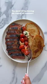 A top-down, instructional recipe video demonstrating how to prepare a steak with blistered cherry tomatoes, mozzarella, and toasted sourdough. The video uses clear, concise text overlays to guide the viewer through the cooking process.