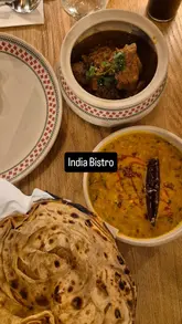 Here are a few options for your alt text, depending on what is actually shown in the photo:

**Option 1 (Focus on the food - best for SEO):**
Delicious lamb curry and puri appetizers served at India Bistro in Chapel Allerton, Leeds.

**Option 2 (Focus on the atmosphere):**
Stunning interior decor and dining atmosphere at the new India Bistro restaurant in Chapel Allerton.

**Option 3 (General):**
A beautifully presented Indian dinner with curry and sides at India Bistro, Chapel Allerton.

**SEO Tip:** If the image is of the food, **Option 1** is the best choice as it includes the restaurant name, location, and the specific dishes, which helps your image show up in local search results.