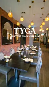 A high-quality, fast-paced montage showcasing the interior and menu of Tyga, an Indian restaurant. The video features close-ups of various dishes, including lamb chops, butter chicken, and desserts, alongside shots of the stylish dining room.