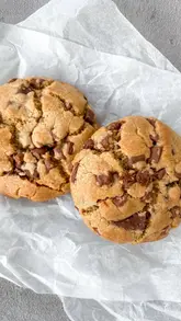 A short, instructional video demonstrating three tips for baking better cookies, focusing on using chocolate chunks, chilling the dough, and underbaking.