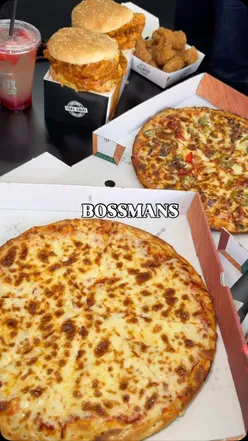 Close-up of a cheesy chicken parmo with fries and a spicy chicken burger from Bossman's M13, Longsight, Manchester.