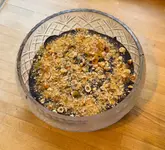 A simple, overhead shot of a homemade chocolate hazelnut mousse in a glass bowl, placed on a wooden surface. The presentation is basic, lacking professional styling or lighting, consistent with a home cooking post.