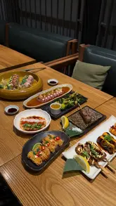 The video features a creator visiting Sticks N Sushi in Victoria to review their limited-edition Sakura menu. It includes shots of the venue, the Sakura Martini, various sushi rolls, skewers, and a dessert, with the creator providing a voiceover review of the experience.