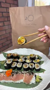 A food haul and review video showcasing a sushi and pan-Asian takeaway menu. The video features close-up shots of various dishes including sushi rolls, gyoza, teriyaki chicken, and spring rolls, highlighting the freshness and variety of the food available for delivery or pickup from local farm shops.