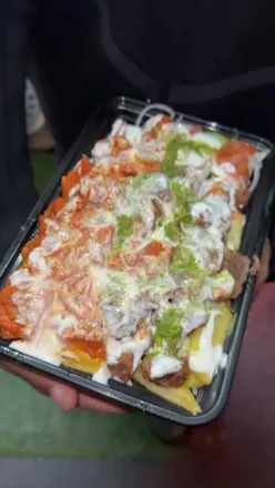 NYC-style halal chicken over rice with white sauce and hot sauce from a halal cart in Birmingham, UK.