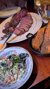 A montage video showcasing a visit to Blacklock restaurant, featuring shots of the exterior, the menu, the dining room, and various dishes including mushrooms on toast, ribs, a large porterhouse steak, and cheesecake.