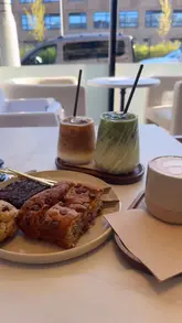 Here are a few options for your SEO alt text, depending on the focus:

**Option 1 (Descriptive & SEO-focused):**
"Assorted cakes, cookies, and artisanal coffee drinks served at Fika aesthetic cafe on Thornton Road, Bradford."

**Option 2 (Focus on the experience):**
"Flat lay of delicious brownies, banana bread, and lattes at Fika, a friendly independent cafe in Bradford."

**Option 3 (Concise):**
"Sweet treats and specialty coffee drinks at Fika cafe on Thornton Road in Bradford."

**SEO Tip:** Always include the location (Bradford) and the business name (Fika) as these are the terms local customers are most likely to search for!