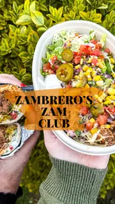 Here are a few options for your SEO alt text, keeping under the 125-character limit:

**Option 1 (Descriptive):**
Customer scanning their phone at a Zambrero restaurant to earn Zam Club loyalty rewards and win prizes.

**Option 2 (Action-focused):**
A person using the Zambrero Zam Club app at the checkout to earn free food, drinks, and enter a £5,000 prize draw.

**Option 3 (SEO-focused):**
Zambrero customer using the Zam Club loyalty scheme to scan for instant rewards, freebies, and competition entries.