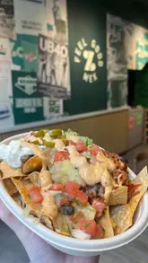 A promotional reel for Zambrero featuring a creator explaining a loyalty app offer, showing the restaurant exterior, menu, and various food items like burritos, tacos, and nachos.