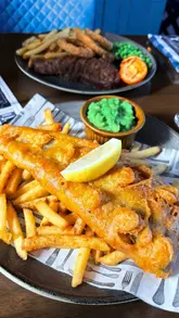 Fish & Chips with crispy batter and an 8oz Rump Steak with fries at The Dove Evington pub, Leicester.
