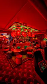 A short, atmospheric video showcasing the entrance and interior of 'Zum Barbarossa', a speakeasy-style cocktail bar in London. The video follows a person walking down into the venue, highlighting the red-lit, ornate decor, the menu, and the cocktails served.