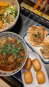 A high-quality, close-up food montage featuring hand-pulled noodle dishes, grilled scallops, various skewers, and fried buns with condensed milk at Belt Noodles in Soho. The video focuses on the textures and preparation of the food, including the DIY grilling aspect of the skewers.