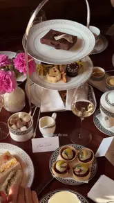 A high-quality, cinematic reel showcasing an afternoon tea service at Raffles London at The OWO. The video features slow, deliberate pans of the elegant dining room, close-ups of the tea service, pastries, and sandwiches, and a live piano player, creating a sophisticated and inviting atmosphere.