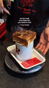 A short, energetic video showcasing the signature hot and iced chocolate drinks at a chocolate bar in London. The video features close-up shots of the preparation, including blowtorching a large marshmallow, and creators enjoying the drinks.