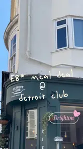A short review-style video showcasing a lunch meal deal at Detroit Club in Brighton, featuring Detroit-style pizza, potato croquettes, and a dipping sauce.